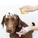 Dog being bathed with silicone bath massage brush, cleaning fur effectively.